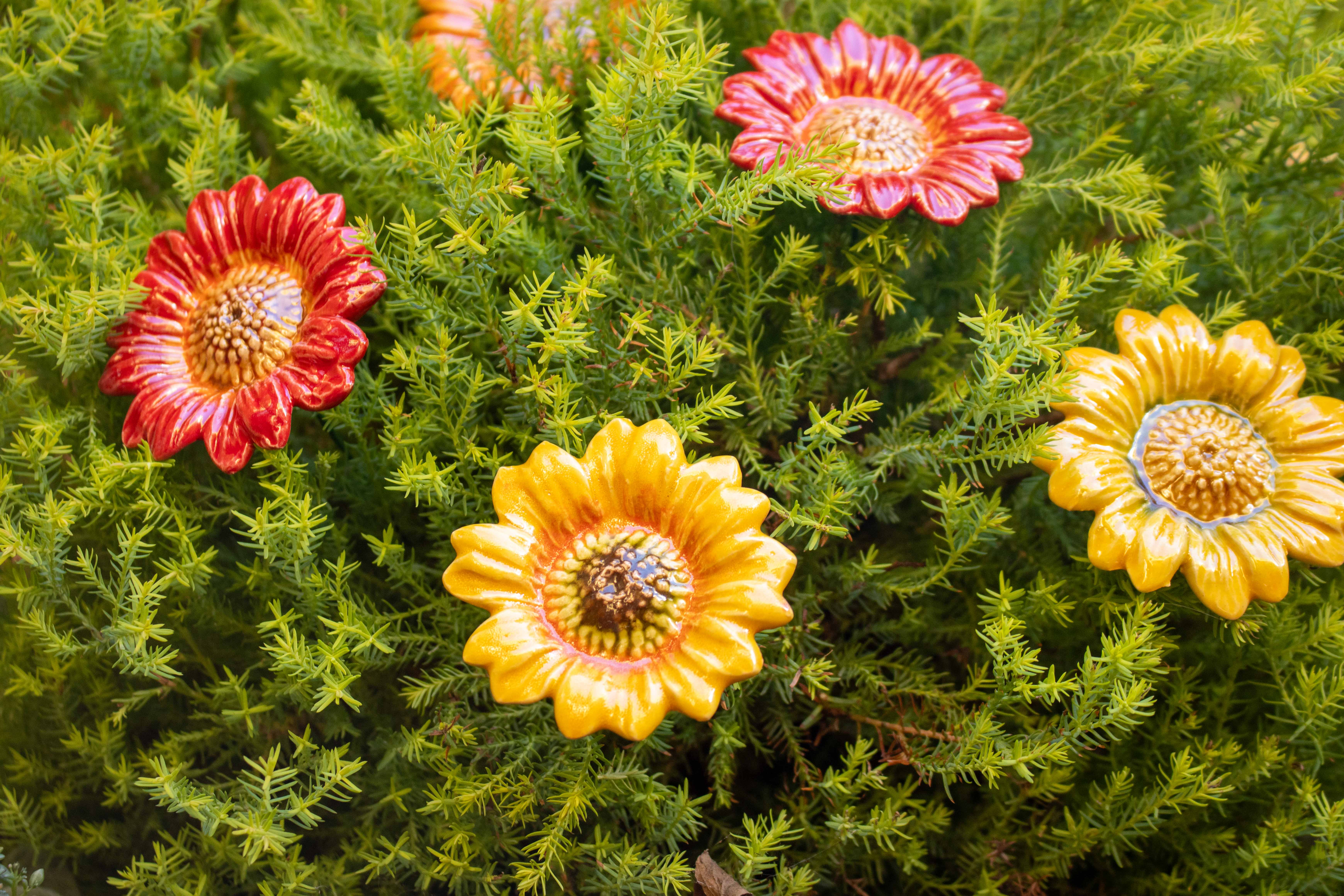 Ceramic sunflowers in green plants