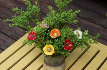 ceramic poppies among live green plants