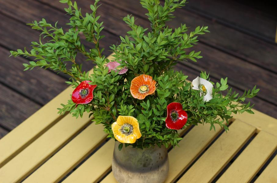 ceramic poppies among live green plants